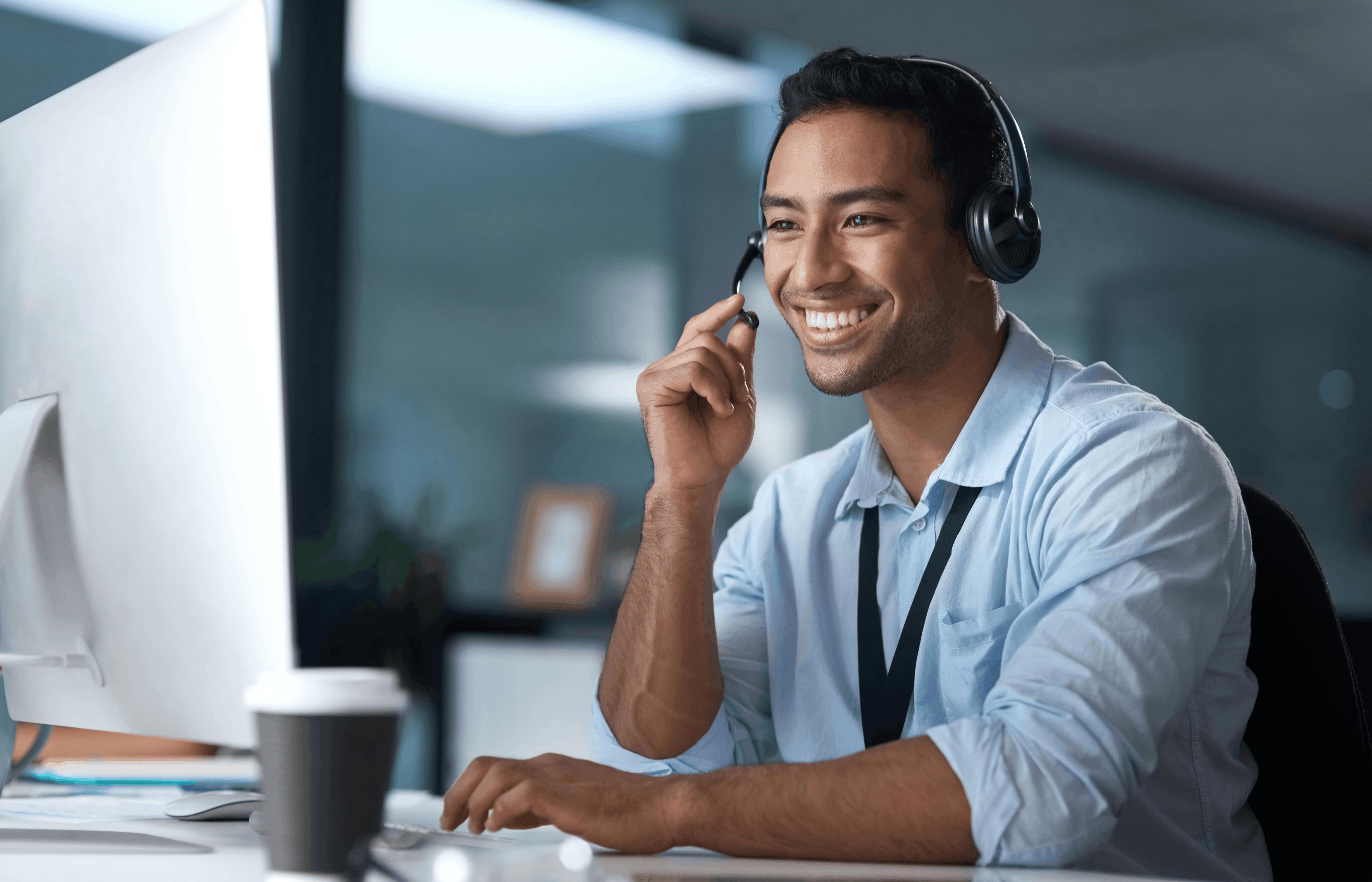  Customer service rep at computer with headset and smiling